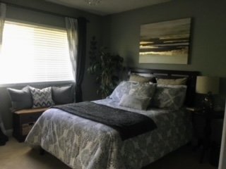 Guest bedroom with charcoal walls, dark wood furniture, and warm lighting