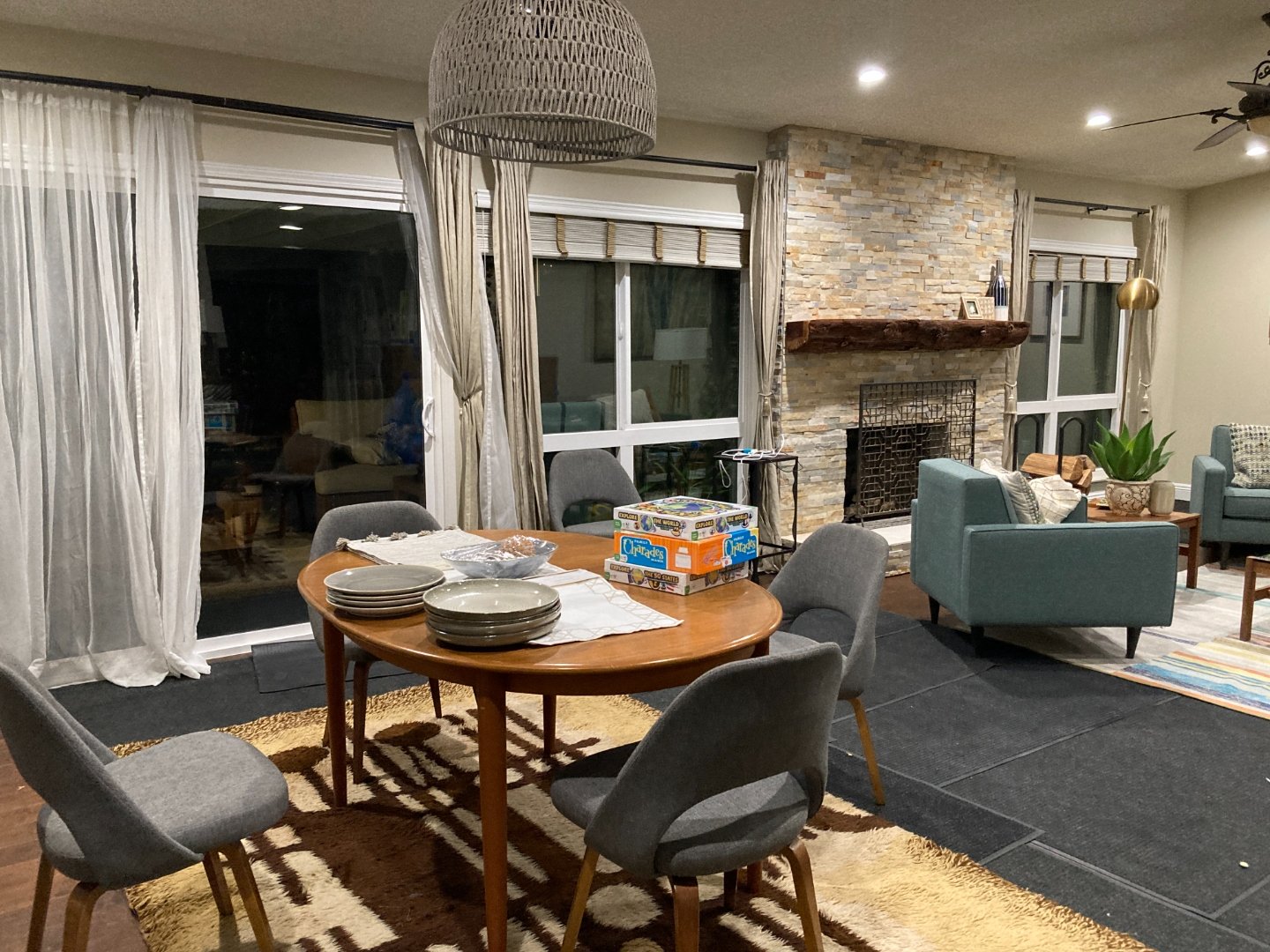 Dining area with round wood table, modern chairs, and oversized woven pendant light