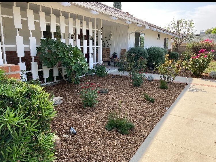 Front porch with white lattice architectural detail and mature landscaping