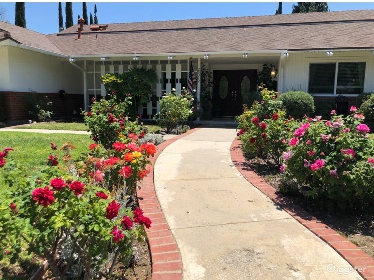 Close view of front entrance with colorful roses and white lattice porch