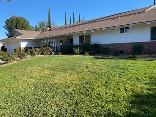 Wide front view of property showing generous lot and mature landscaping