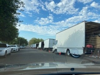 Long line of production trucks and trailers staged on the street