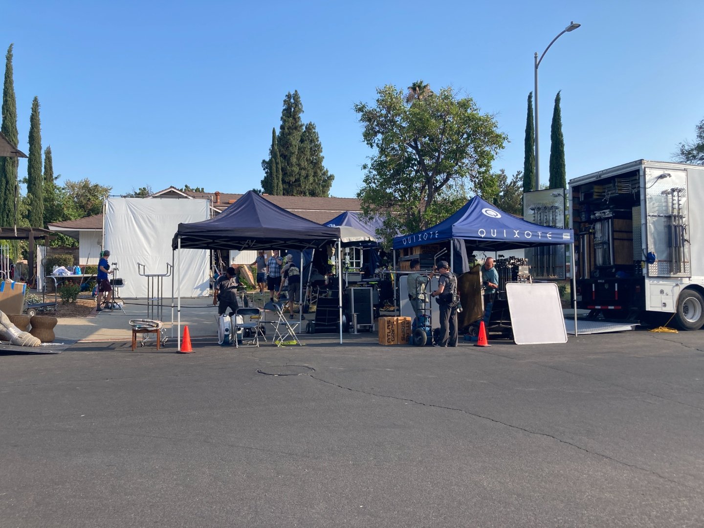 Full production setup showing Quixote tents, grip trucks, equipment, and crew working on location