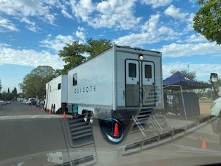 Quixote production trailer and support vehicles staged near the property